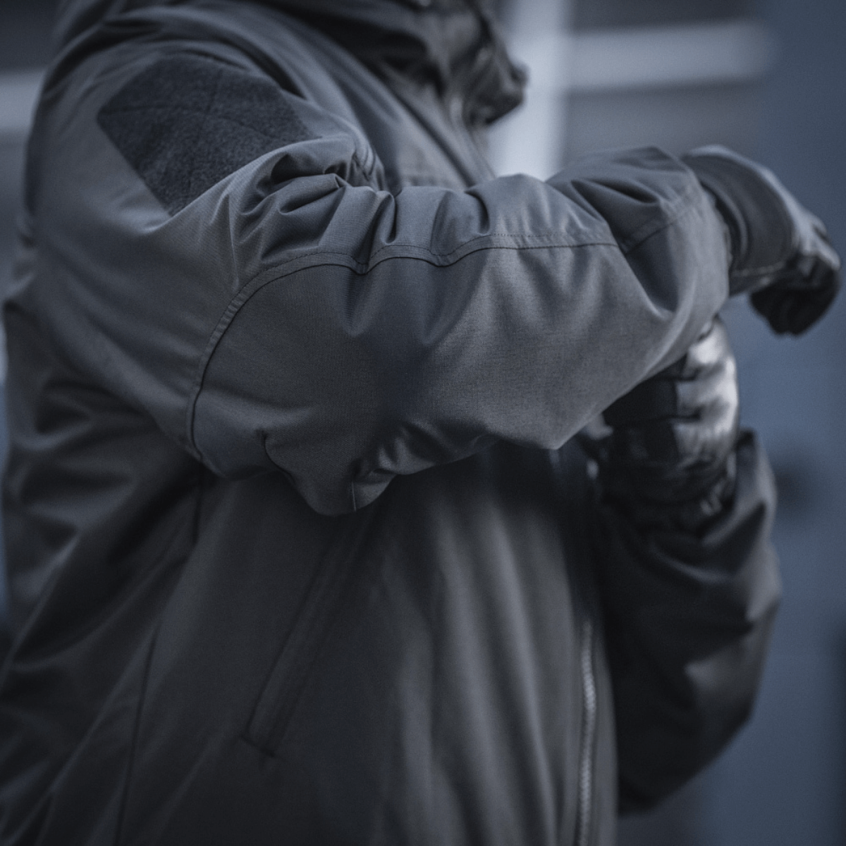 Detaljeret visning af M-Tac Alpha Gen.III Pro Vinterjakke, viser forstærkede albueområder og vandtæt nylonmateriale.