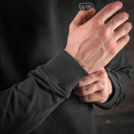 Detalje af M-Tac Raglan Athlete sweatshirt med ribmanchetter, sort farve, designet til komfort og bevægelsesfrihed, set i nærbillede.
