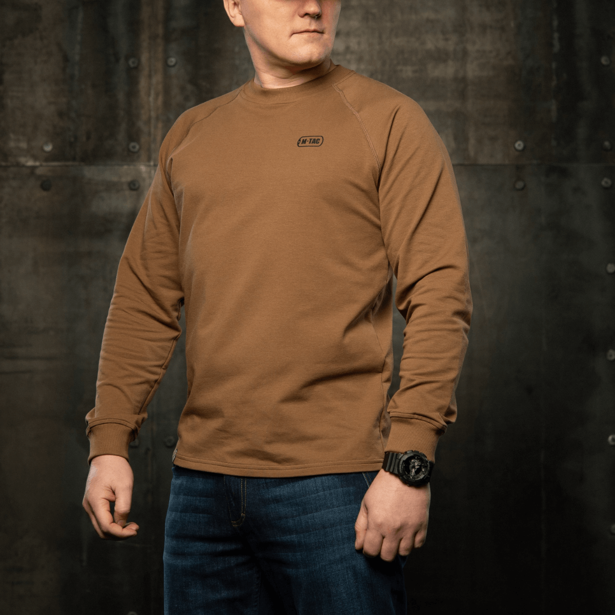 M-Tac Raglan Athlete sweatshirt med rund hals og raglanærmer i coyote, perfekt til sport og daglig brug, set i en industriel setting.