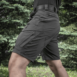 M-Tac Aggressor Summer Flex Shorts i brug i udendørs omgivelser, viser letvægts-taktisk design og funktionelle lommer.