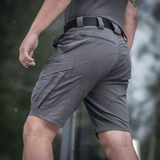 Mand iført M-Tac Aggressor Summer Flex Shorts med lommelygte og elastisk talje