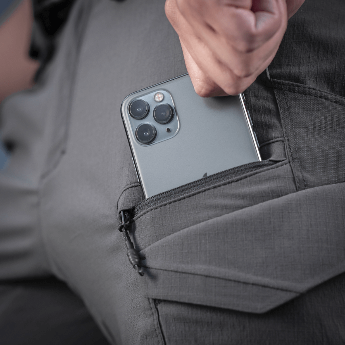 M-Tac Aggressor Summer Flex Shorts with phone in side pocket showcasing functionality and Flex Rip-Stop fabric in dark grey.