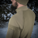 M-Tac Combat Fleece Polartec Jakke set fra siden i naturligt miljø, fremhæver kvalitetsmateriale og funktionelt design, ideel til vinterbrug.