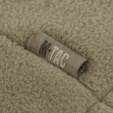 Nærbillede af M-Tac Combat Fleece Polartec Jakke i olivengrøn, viser detaljeret struktur og mærket på fleece materialet.