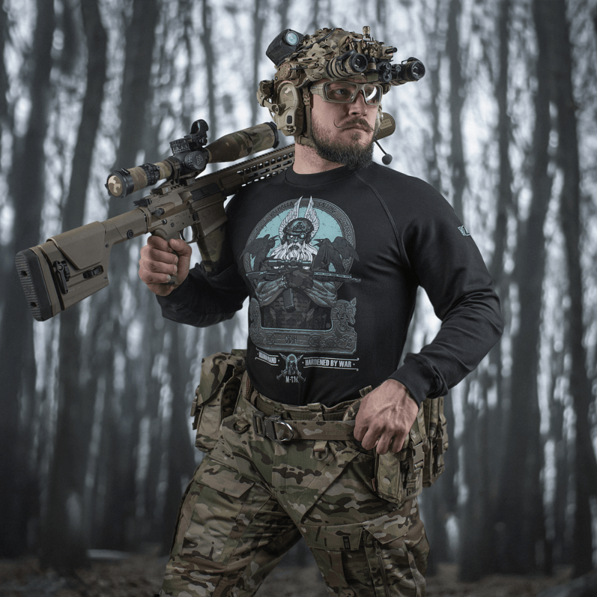 Mand iført M-Tac Raglan Odin Mystery med Odin-motiv i skovmiljø, perfekt til taktisk stil. Lavet af 95% bomuld, 5% elastan.