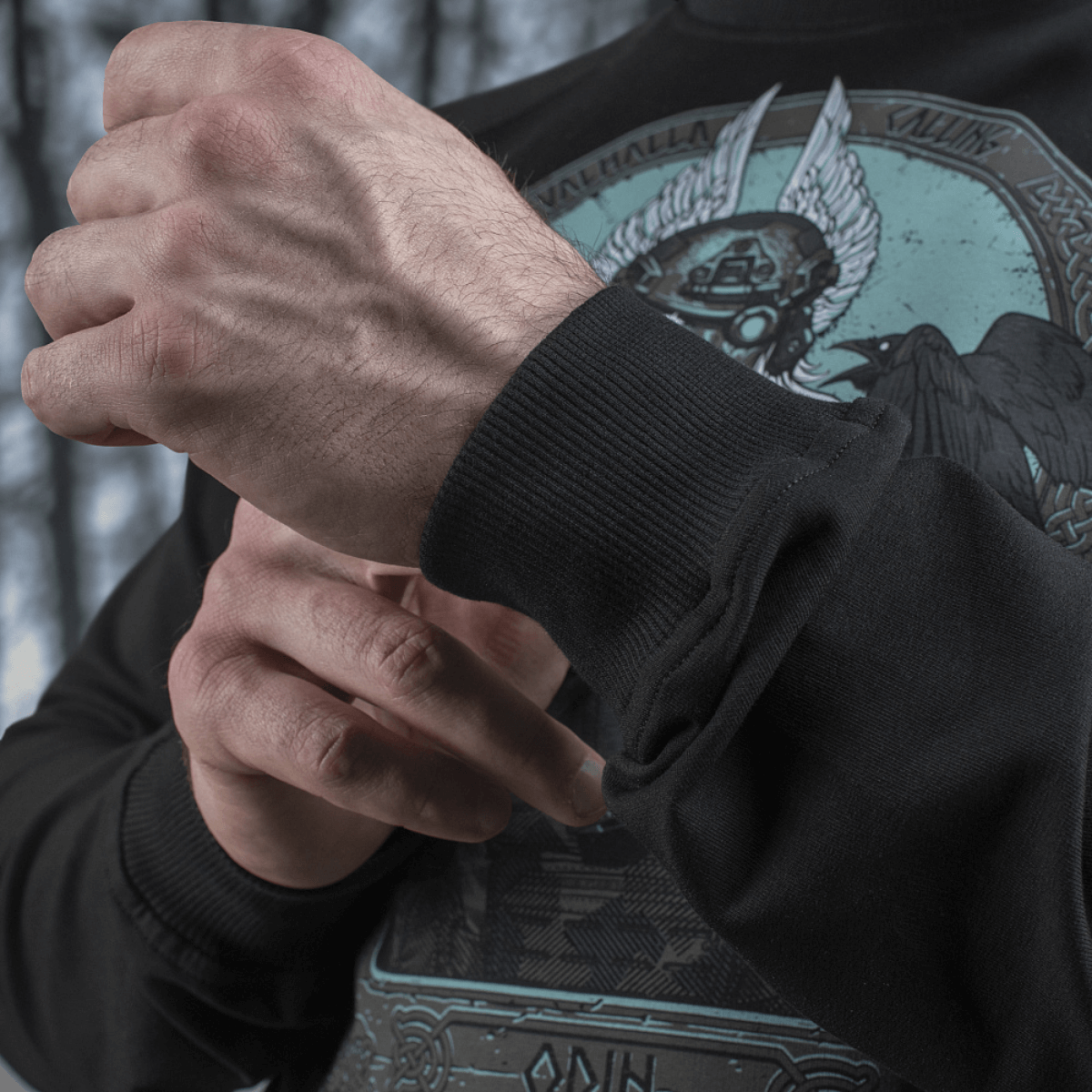 Mand iført M-Tac Raglan Odin Mystery trøje med motiv af Odin, viser ærmedetaljer. Ideel til casual/taktisk brug.