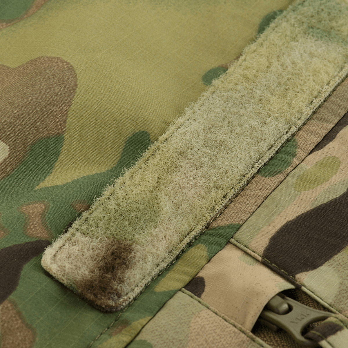 Detalje af M-Tac Alpha Gen.IV Pro Primaloft Vinterjakke med original Multicam-mønster og slidstærkt velcrolukning.