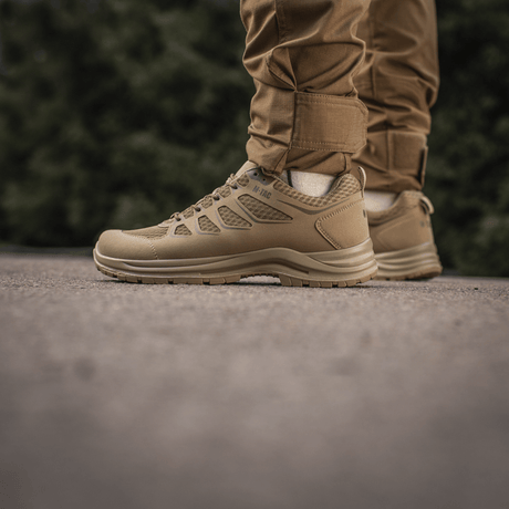 Person iført M-Tac Tactical Sneakers IVA til udendørs aktiviteter, lette og ventilerede sko ideelle til trekking og hverdag.