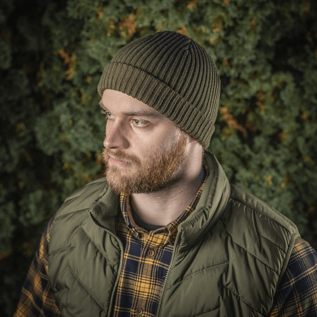 M-Tac Watch Cap 100% Akryl strikhue, perfekt til koldt vejr, på mand i skov, holder hovedet varmt og stilfuldt.