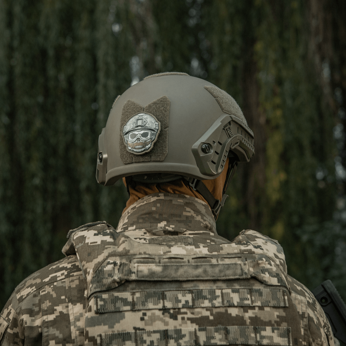 M-Tac Patch Emoji #4 med 3D-effekt monteret på en taktisk hjelm med camouflagebaggrund. Sjovt morale patch til udstyr.