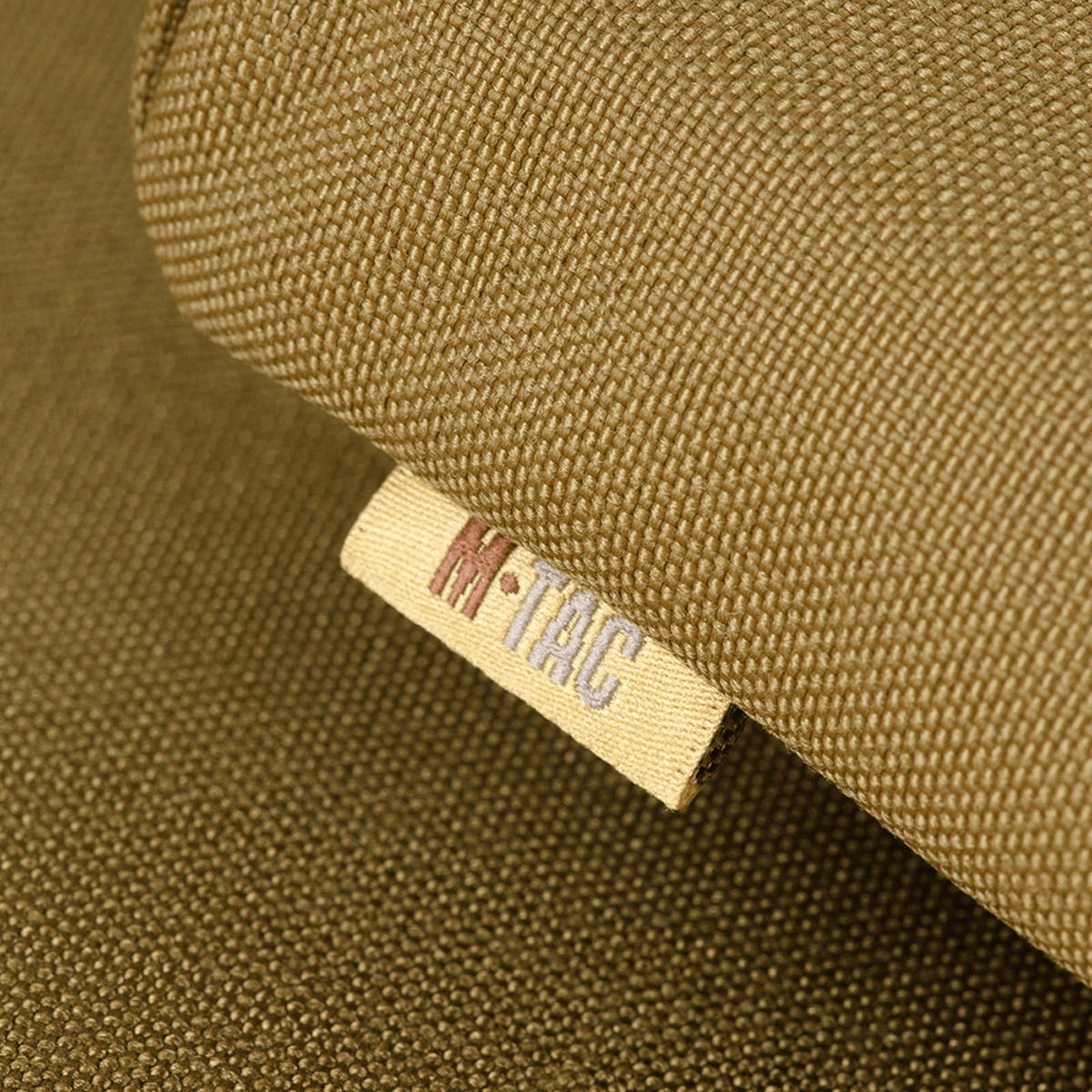 M-Tac Siddeunderlag med bæltebeslag ARMOR i Cordura 1000D, nærbillede af mærket, ideel til beskyttelse mod kulde og fugt.