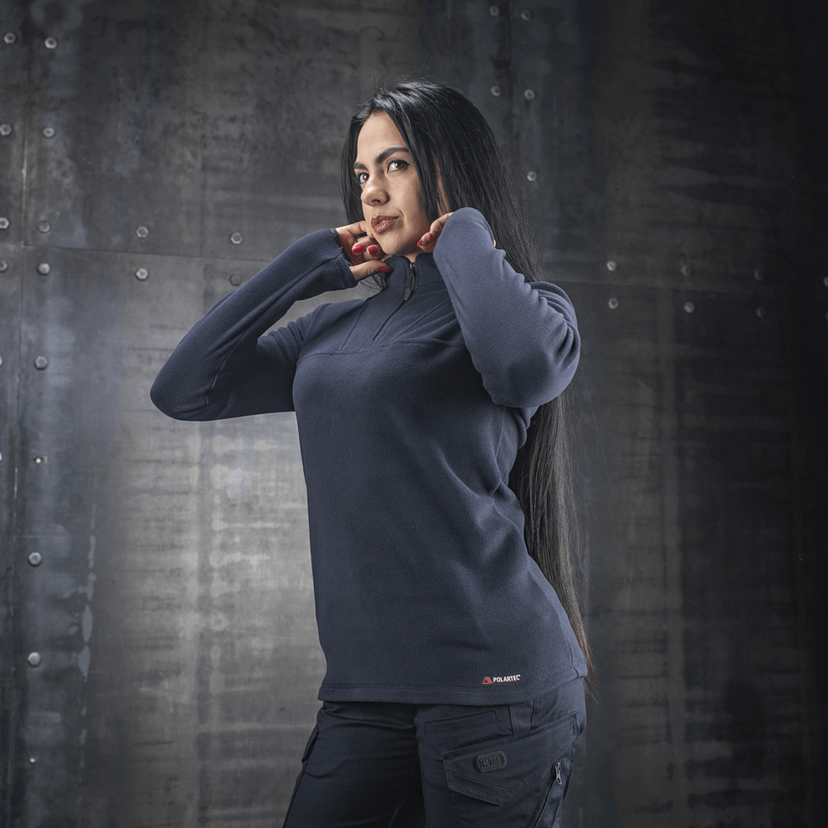 Kvinde iført M-Tac Delta Polartec Fleecejakke Dame i mørkeblåt, fremstillet af Polartec® Micro Series-fleece for komfort og varme.