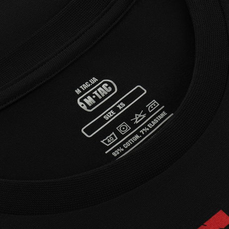 Nærbillede af M-Tac T-Shirt Freedom label, XS størrelse, 93% bomuld, 7% elastan. Viser vaskeanvisninger og mærkelogo.