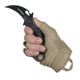 En hånd der bærer M-Tac Fingerløse Handsker Assault Tactical Mk.4 med en kniv i et fast greb