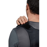 Bagside af person iført Anorak Concealable III Cover med justerbar velcro-strop for skjult panserbeskyttelse. Ideel til diskreet brug.