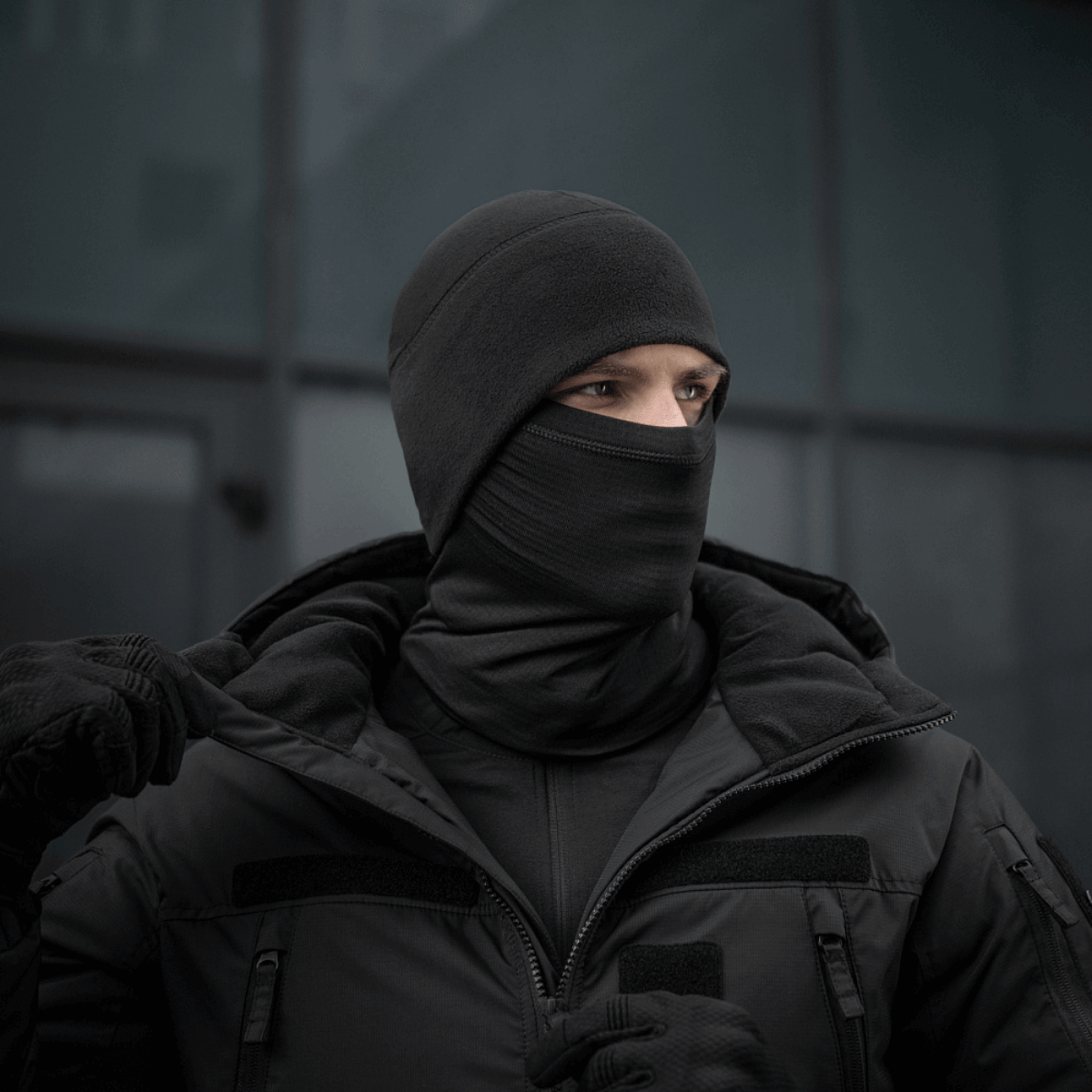 Person iført M-Tac Tube Scarf Polartec Power Grid, sort halsrør som maske i vintermiljø.