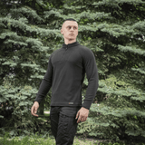 Mand iført M-Tac Delta Polartec Raglan Jakke i naturen, ideel til udendørs aktiviteter og hverdagsbrug, med Polartec® Micro Series fleece.