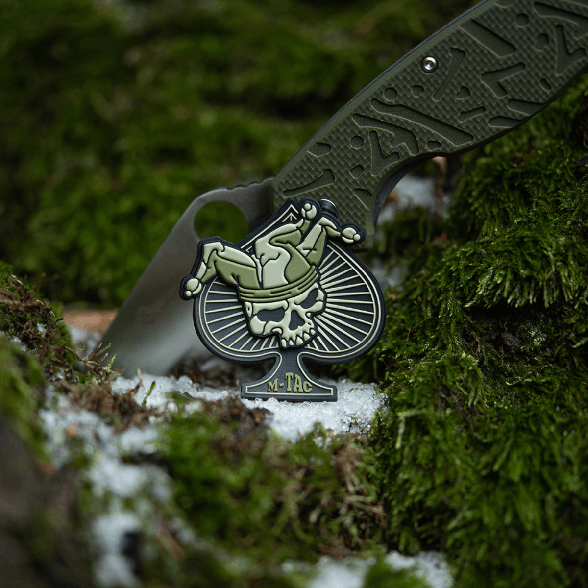 M-Tac Ace of Spades 3D PVC Patch med velcro på mos i naturen. Taktisk morale patch til militær, airsoft og outdoor brug.