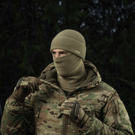 Person iført M-Tac Fleece Polartec Watch Cap i koldt udendørs miljø, perfekt til vinteraktiviteter med kamuflagejakke.
