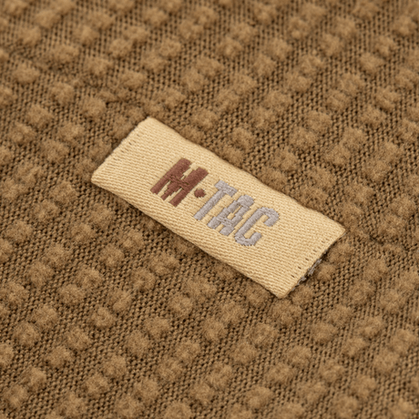 Nærbillede af M-Tac Hjelm Watch Cap Polartec med logo, lavet af slidstærkt Polartec fleece, velegnet til køligt vejr med anti-pilling egenskaber.