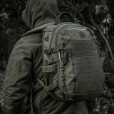 Rygsæk med M-Tac Karabinhage 10 cm i militært udstyr, fremstillet af 40Cr legeret stål, vist i udendørs skovmiljø.