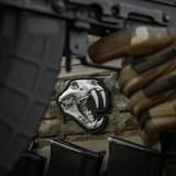 Detaljeret M‑Tac Patch Old Tiger PVC-patch med tigerkranium og 3D-effekt, fastgjort på militærudstyr med velcro.