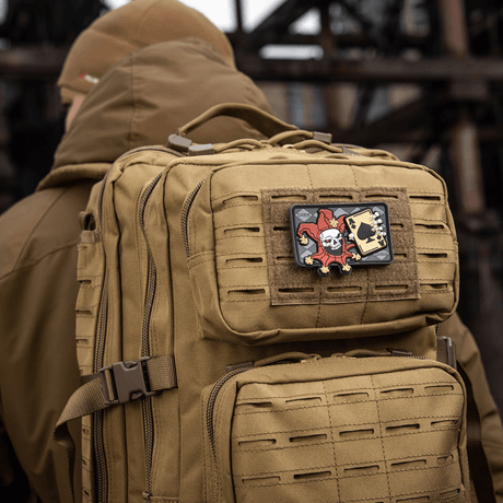Taktisk rygsæk med M-Tac Patch Joker Skull 3D PVC med joker og dødskort i PVC, påmonteret på ryksekens forside.