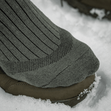 M-Tac Sokker Mid Calf Mk.4 til mænd, i brug under trekking i sne, med polstrede områder for beskyttelse og støtte.