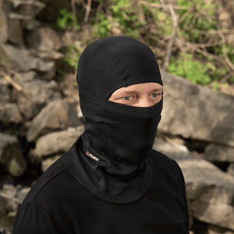 Mand bærer M-Tac Sweater-Ninja-Balaclava Premium i sort udendørs, optimal til komfort og fugthåndtering, med flade sømme og elastisk stof.