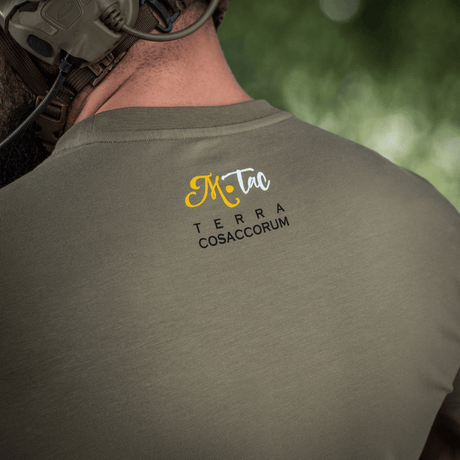 M-Tac T-Shirt Motanka set bagfra med teksten 'Terra Cosaccorum' trykt på ryggen. Moderne design møder ukrainsk kulturarv.