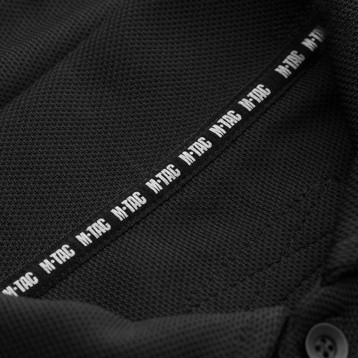 Nærbillede af M-Tac Tactical Polo Shirt 65/35 med M-Tac mærke, ideel til politi- og sikkerhedsarbejde i bomuld og polyester for komfort.