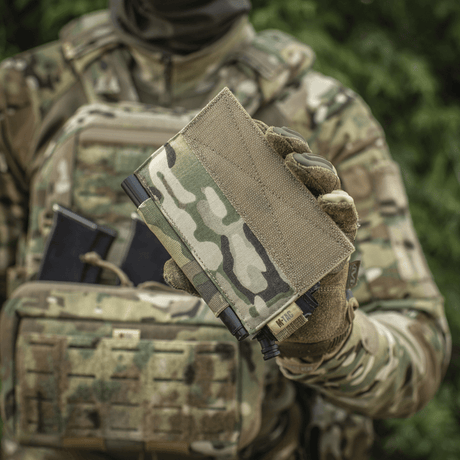 M‑Tac Tourniquet Pouch Elastic Gen.5 holdt af soldat i camouflageuniform, ideel til CAT tourniquet på taktisk udstyr.