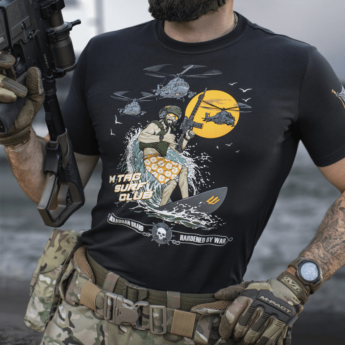 M-Tac T-Shirt Surf Club med specialstyrkesoldat på surfbræt, inspireret af klassiske krigsfilm og ukrainske specialoperationer.