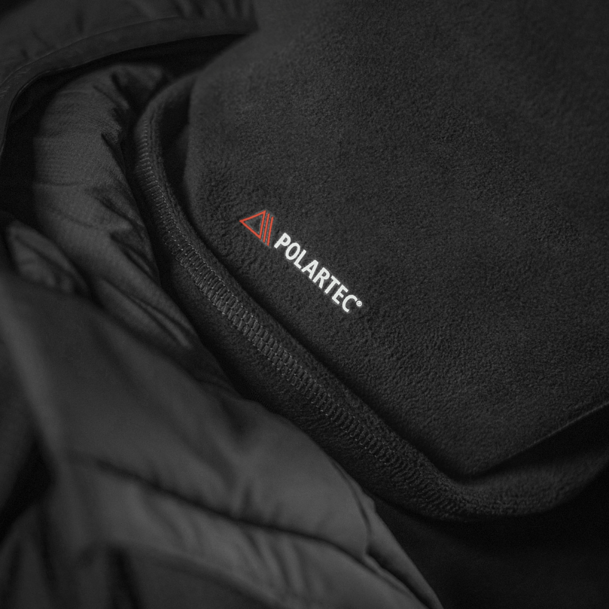 M-Tac Tube Scarf Polartec i sort fleece, som er stilfuldt og varmende for udendørs aktiviteter, fremstillet i Polartec® Micro Series.