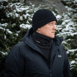 Mand iført M-Tac Tube Scarf Polartec foran sneklædte grantræer; varm multifunktionel halstørklæde til udendørs brug i kolde årstider.