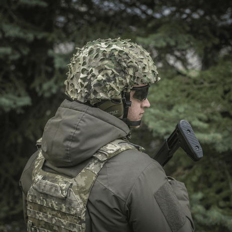 Soldat iført M‑Tac Vilha Hjelmcover Elite i MULTICAM-camouflage for beskyttelse og skjul i naturen, designet til FAST hjelme.