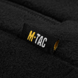 Label på M-Tac Combat Fleece Jakke Dame – Polartec og taktisk, viser mærkelogo på sort fleece materiale.