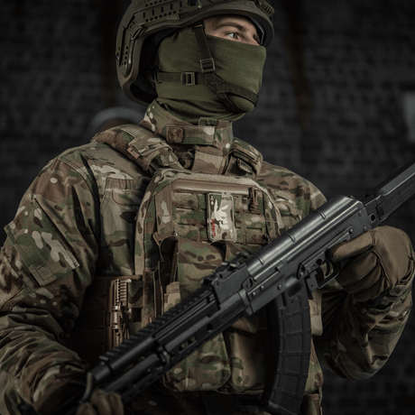 Soldat i kamouflagedragt med M-Tac Patch Bad Boy (Broderi) på vesten, udstyret med stormgevær, symboliserer styrke og mod.